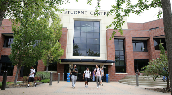 three students walk in front of the JCCC student center 